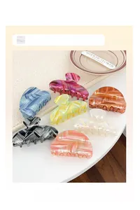 Detailed view of large wave-textured hair claw clips in seven diverse gradient colors