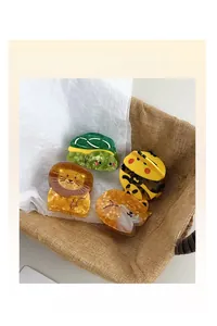 Detail of four acetate cartoon animal hair claws including turtle, bee, lion, and fox styles