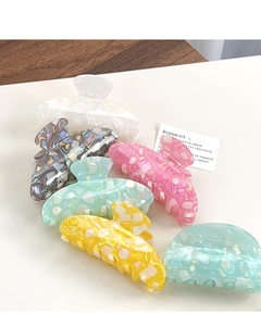 Detailed overhead view of six colorful marbled acetate hair claws with premium metal springs