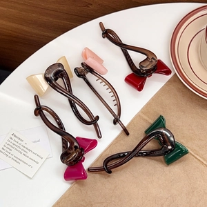 Elegantes pinzas para el cabello con lazo de acetato en cinco colores sobre bandeja blanca