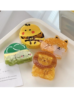 Detailed view of acetate hair claws featuring bee, lion, cat and turtle cartoon designs