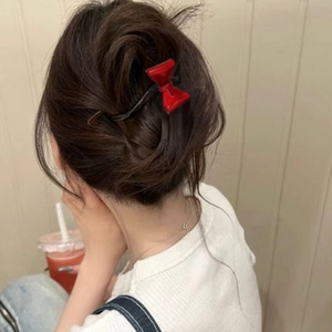 Elegante pinza para el pelo con lazo rojo de acetato para mujer en un peinado recogido