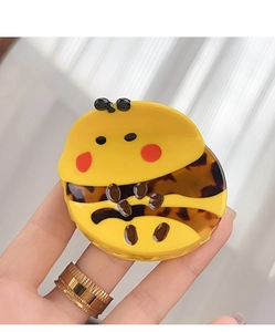 Detailed macro view of yellow honey bee hair claw clip showing glossy acetate finish