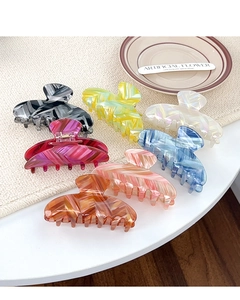 Macro detail of multicolored acetate hair claws with premium herringbone texture and metal spring