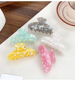 Detailed set of five colorful marbled hair claws in pink, yellow, and blue finishes