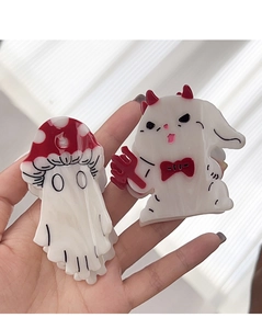 Detail of acrylic Halloween hair clips featuring a mushroom ghost and a white devil animal