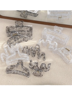 Detailed close-up of acrylic hair claws with elegant black and white lace patterns