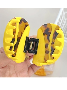 Close-up of yellow and tortoise shell acetate hair claw clip showing strong metal spring