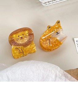Detail of cute acetate animal hair claws featuring lion and fox marble patterns