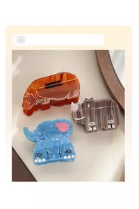 Detail of cartoon animal hair clips featuring orange hippo and blue elephant designs