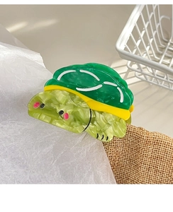 Detailed view of the turtle hair claw clip showing its emerald green marble texture