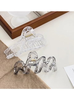 Close-up of elegant acrylic hair claws with black and white lace patterns and metal springs