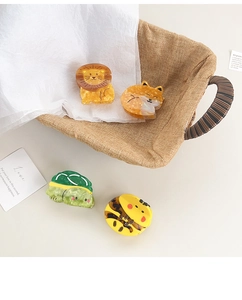 Set of four cute animal-shaped acetate hair claws including lion, bee, and turtle