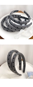 Detail showing grey denim-style headband with black heart and bow pattern and handmade label