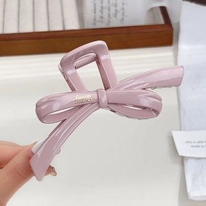 Elegant large glossy bow hair claw clip in soft mauve resin for thick hair styling