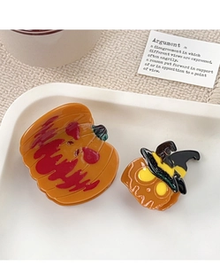 Détail de pinces à cheveux citrouille d'Halloween avec chapeau de sorcière sur assiette
