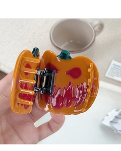 Détail d'une pince à cheveux citrouille d'Halloween en acétate orange brillant