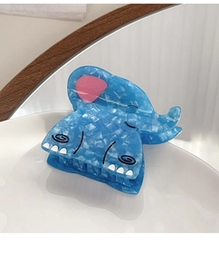 Detailed view of the blue marble-textured acetate elephant hair claw clip in a ceramic dish