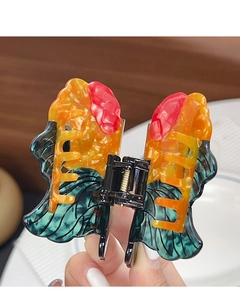 Detailed macro view of butterfly-shaped hair claw made of marbled acetate in vivid colors