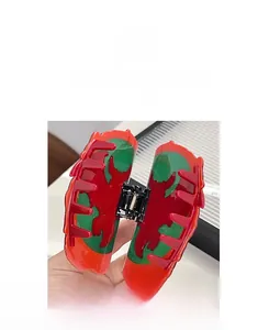 Detailed view of the green and red dragon emblem hair claw clip with tassel accents