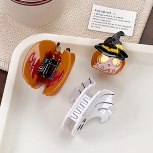 Lot de pinces à cheveux Halloween citrouille et fantôme sur un plateau décoratif blanc