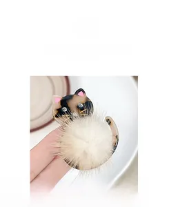Detail einer kreativen Katzen-Haarklammer mit Schildpatt-Muster und weißem Plüsch-Pompon