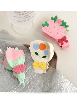 Détail des pinces à cheveux en acétate avec motifs de tulipes et roses en rose pastel