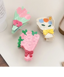 Détail des pinces à cheveux en acétate avec bouquet floral 3D et nœud multicolore