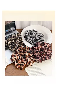 Vista dettagliata di quattro elastici scrunchie leopardati in chiffon marrone, grigio e arancio