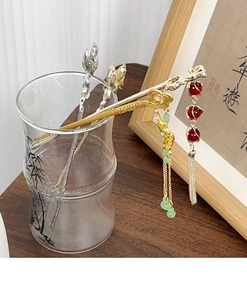 Detailed view of Chinese style metal hairpins with tassels and red beads
