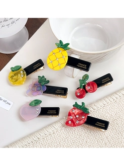 Detailed view of handmade acetate fruit hair clips with sparkling crystal rhinestones