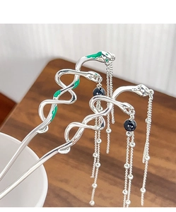 Detailed close-up of snake hair pins with green enamel and black bead tassel chains