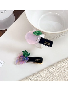 Close-up of peach and grape acetate hair clips with gold France Handmade lettering