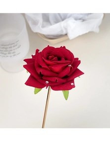 Close-up of elegant red rose hair pin with velvet texture and sparkling rhinestones