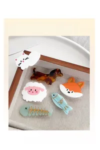 Detail view of cute acetate hair clips featuring cartoon cat, dachshund, and lamb designs