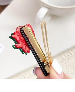 Close-up of red flower acetate hair clip with a golden non-slip metal duckbill base