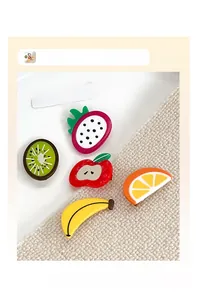 Close-up of cute acrylic hair clips in apple, banana, and kiwi fruit shapes