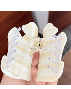 Détail de la pince à cheveux papillon avec rayures crème et ressort doré
