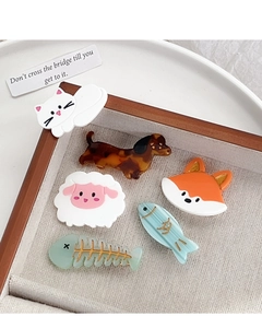 Detailed view of cartoon animal acetate hair clips in a wooden box for styling