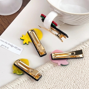 Cute fruit-shaped acetate hair clips with pineapple and lemon designs on metal base