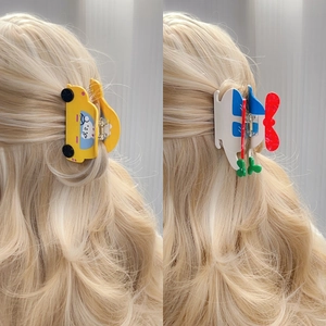 Cute car and helicopter hair claws on blonde hair for creative hairstyling