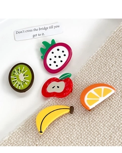 Detail of five colorful acetate fruit hair clips including kiwi and orange shapes
