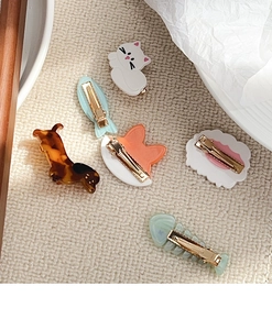 Detailed close-up of six creative acetate duckbill hair clips with various animal shapes