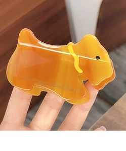 Détail de la pince à cheveux en acétate ambré avec motif silhouette de chien Scottie