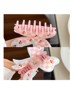 Detailweergave van de haarclip met strik met roze ruitpatroon en kersenprint ontwerp