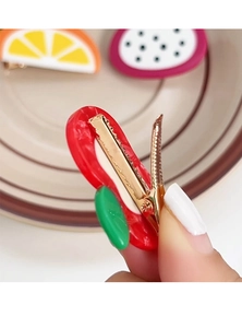 Detail of gold metal duckbill clip on the back of a cute red fruit acetate hair clip