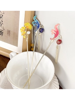 Détail d'épingles à cheveux chinoises avec feuilles de ginkgo et pompons dans une tasse