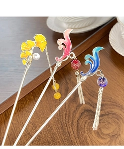 Détail de trois épingles à cheveux chinoises vintage avec glands élégants et motifs ginkgo