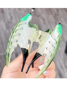 Macro view of bird-shaped claw clip featuring green gradient acetate and metal spring