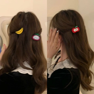 Cute acetate fruit hair clips with apple and banana shapes on wavy brown hair